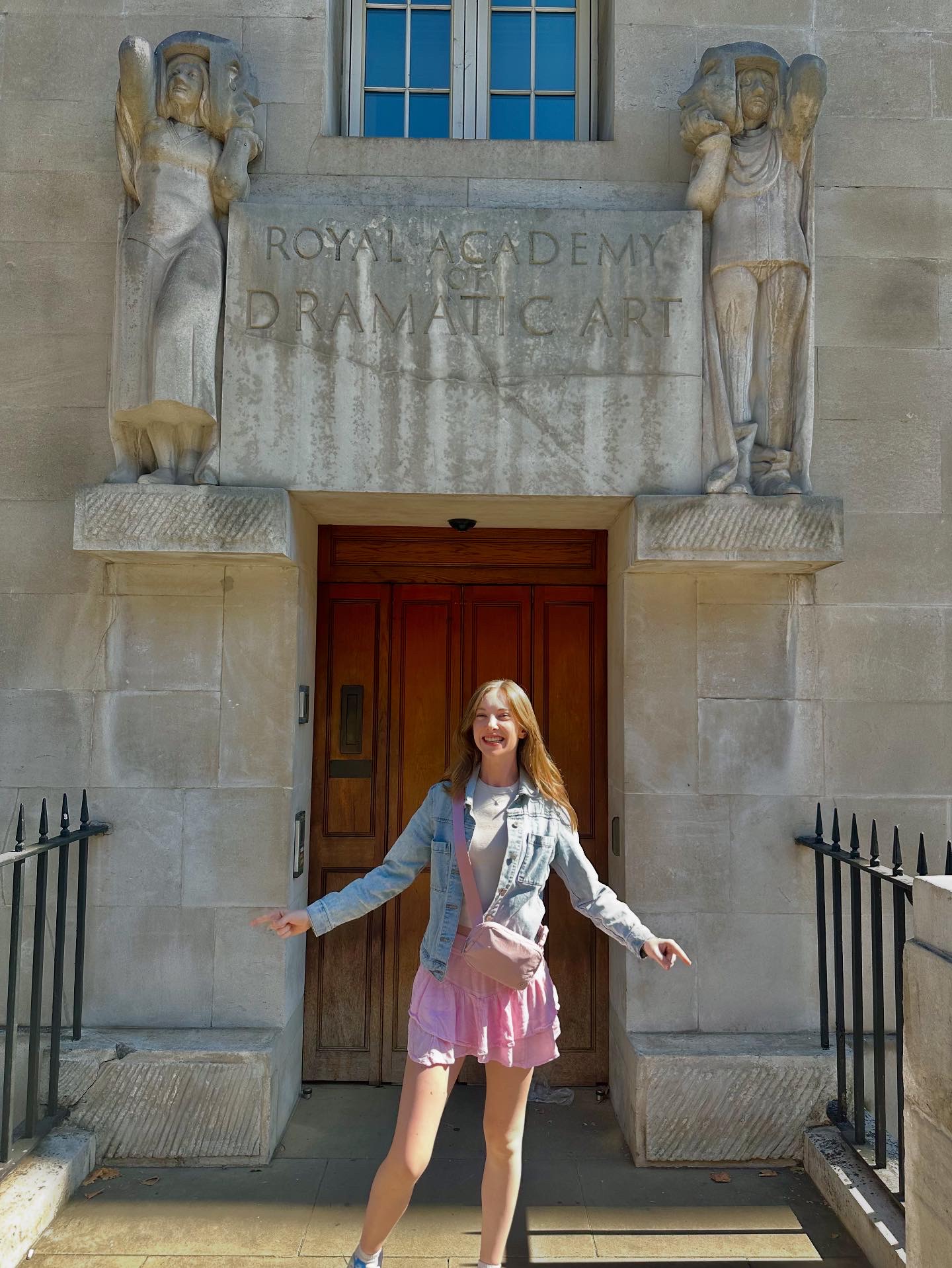 NYU student stands in front of the Royal Academy of Dramatic Art building.