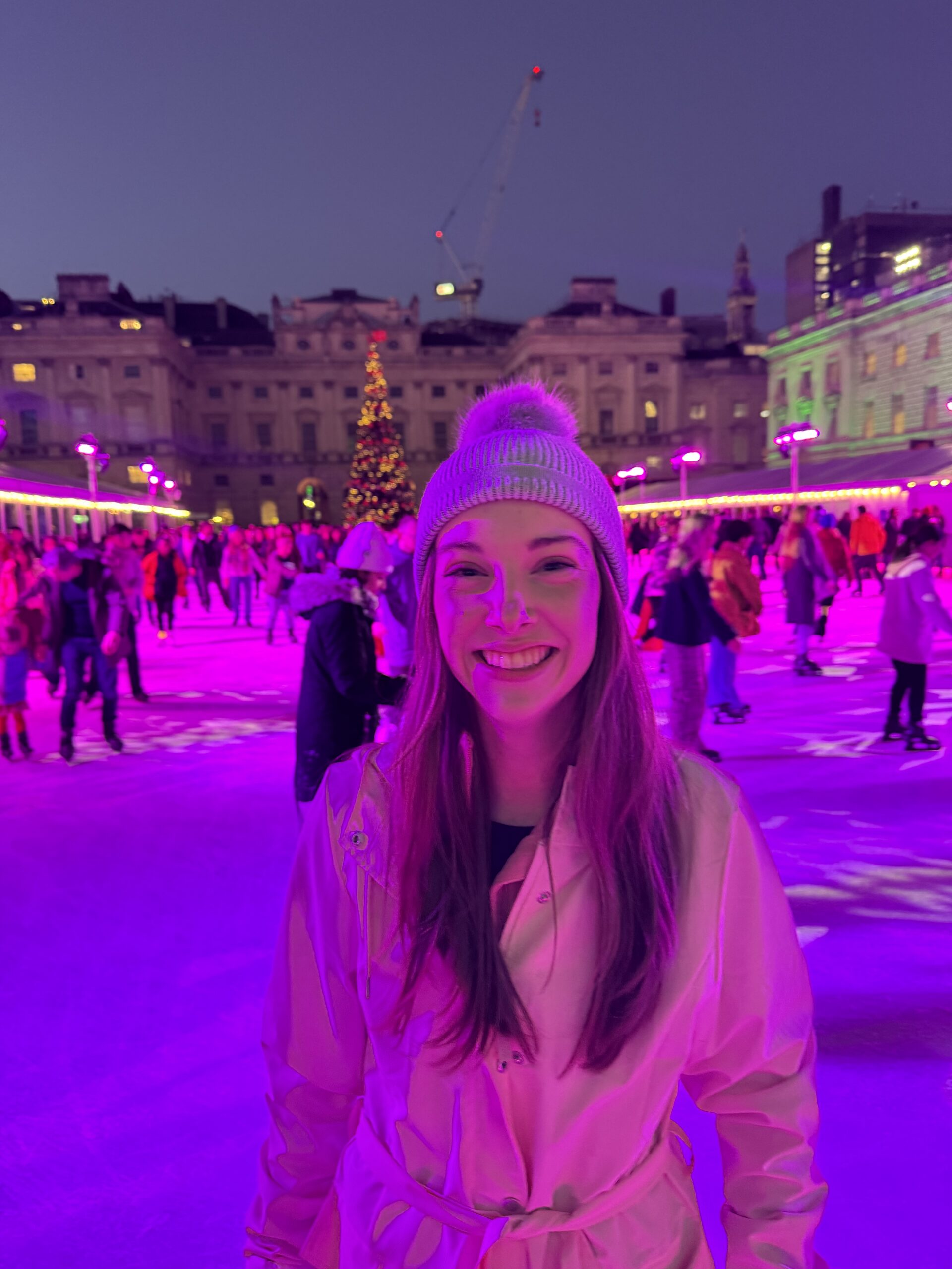 Student stands in winter clothes on an ice rink.