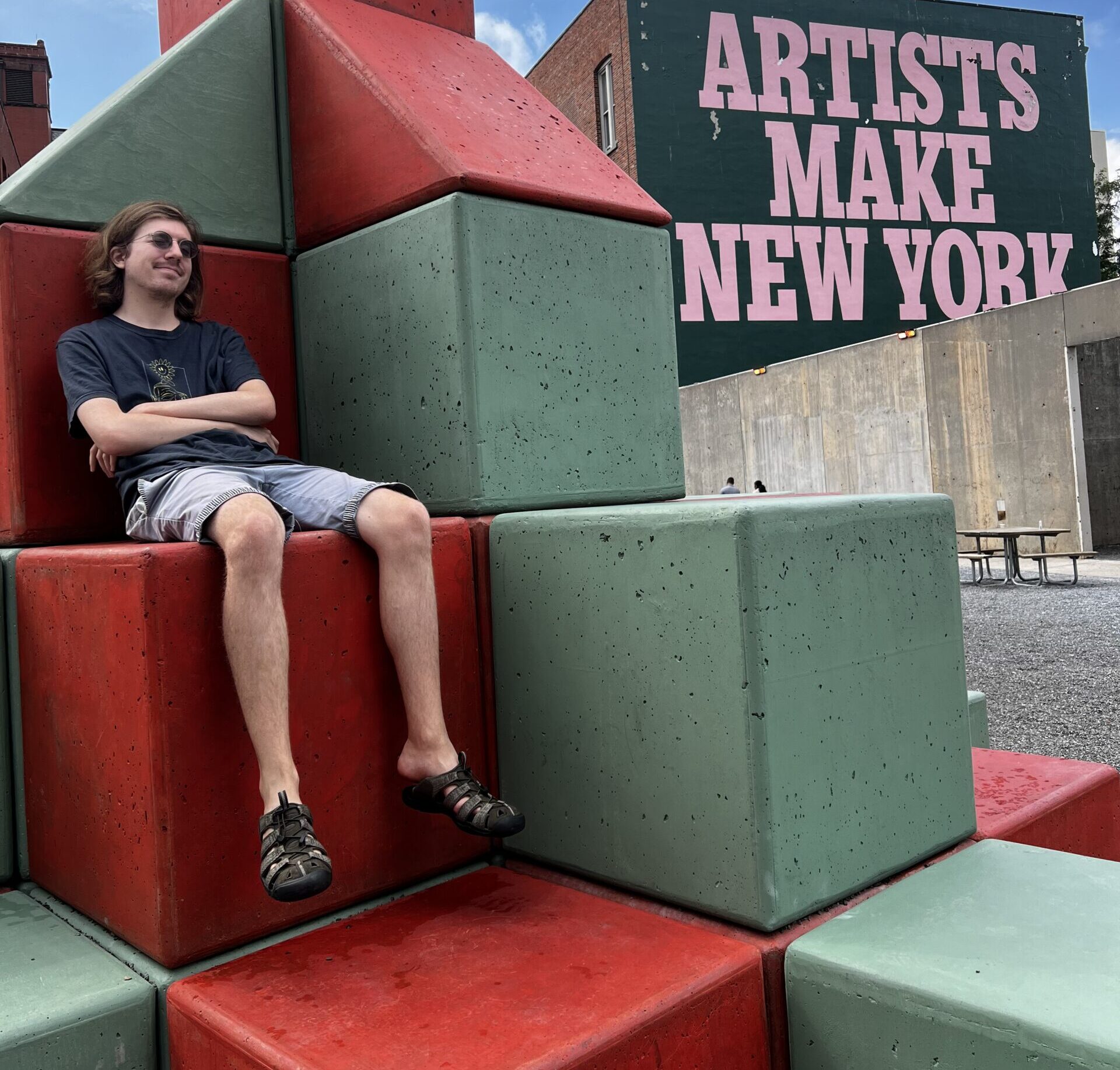 Parker sitting on large colorful blocks in an installation at MOMA PS1.