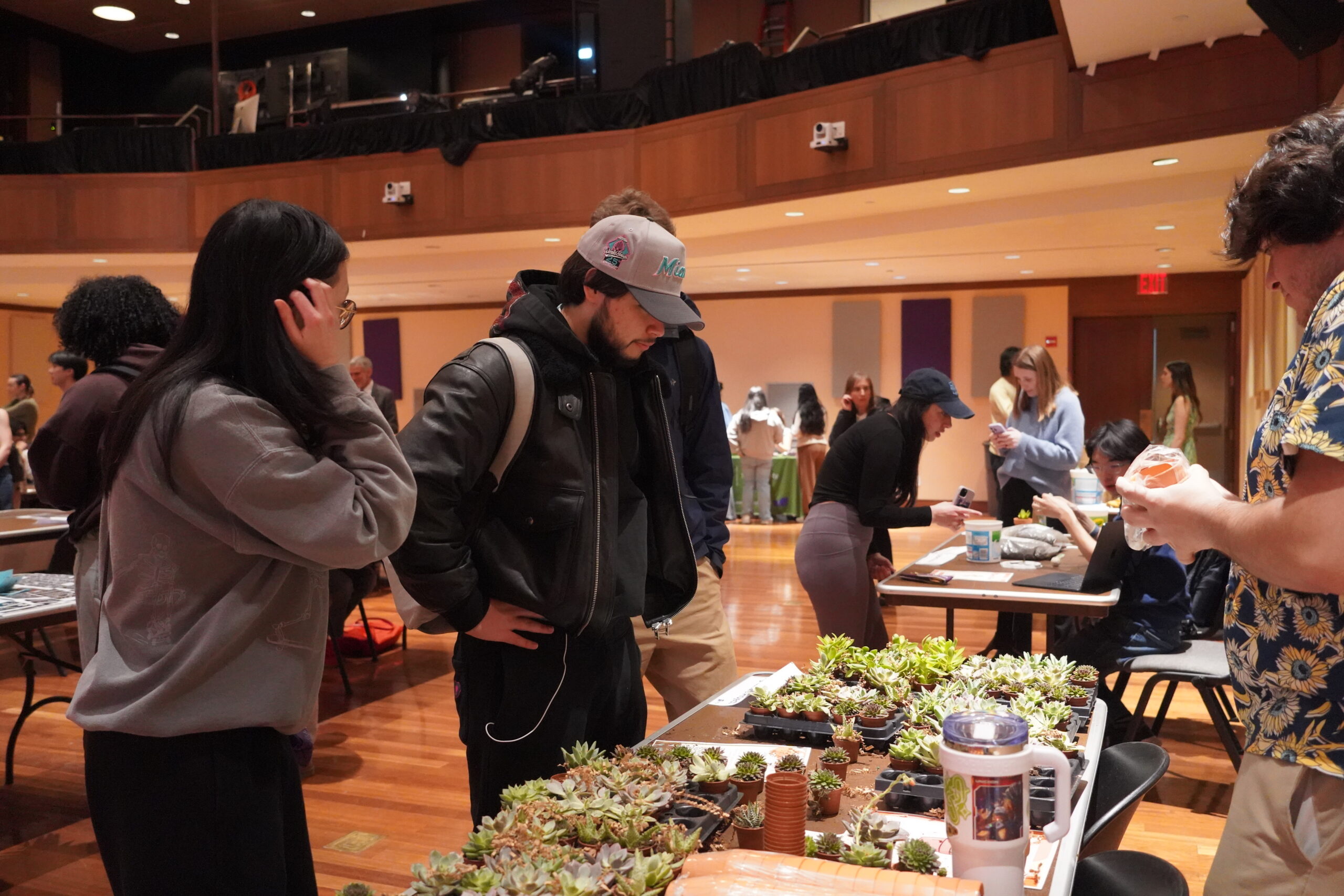 Students visiting a booth with multiple potted plants at Earth Fest.