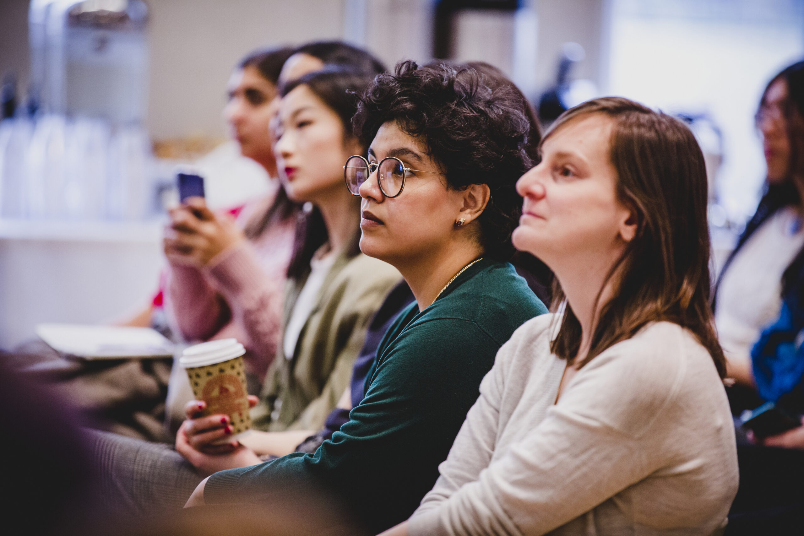 A group of students listen to a presentation.
