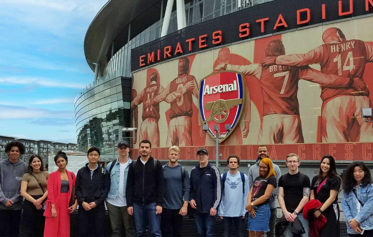 A group of students stand outside The Emirates Stadium.