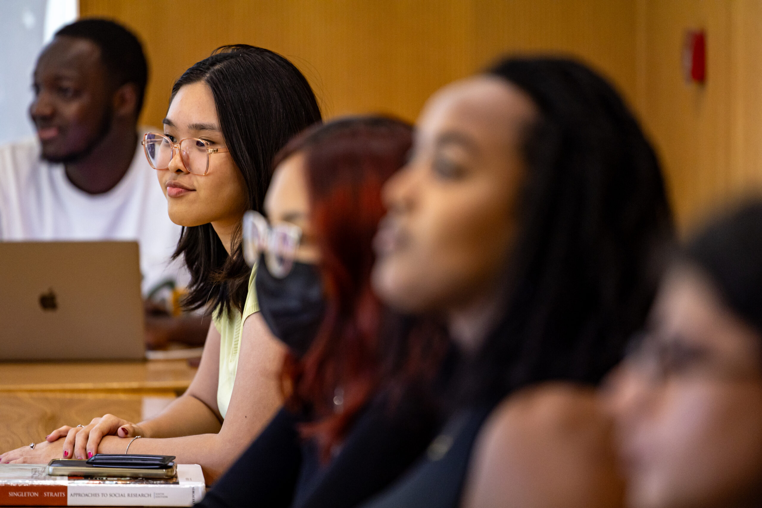 A group of students listens intently in a classroom setting.