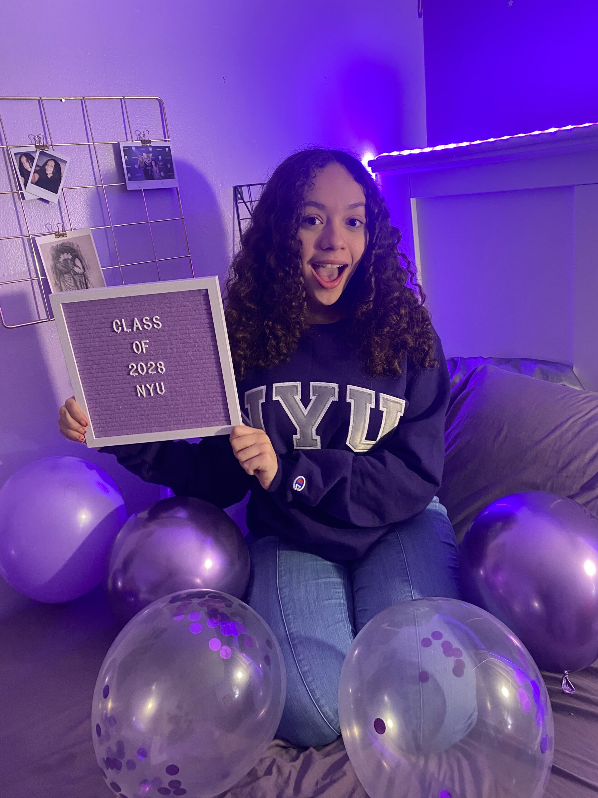 Woman seen holding a purple board reading 